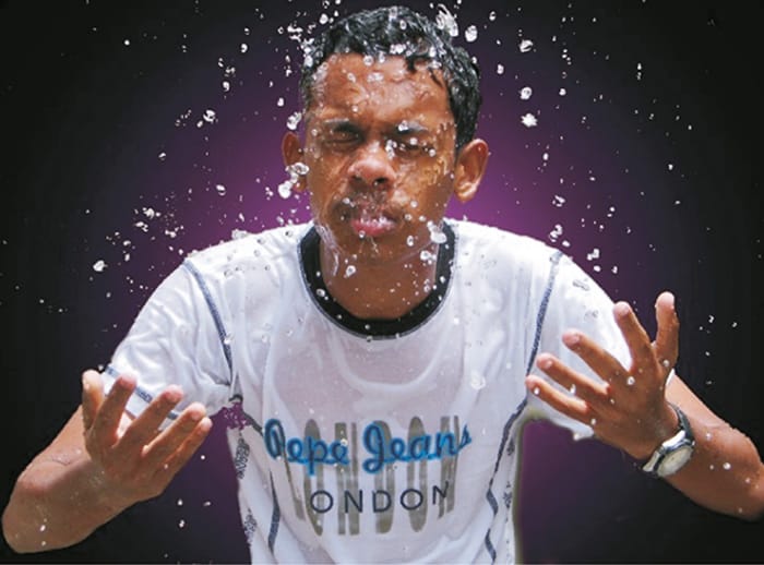 Young boy splashing water on his face